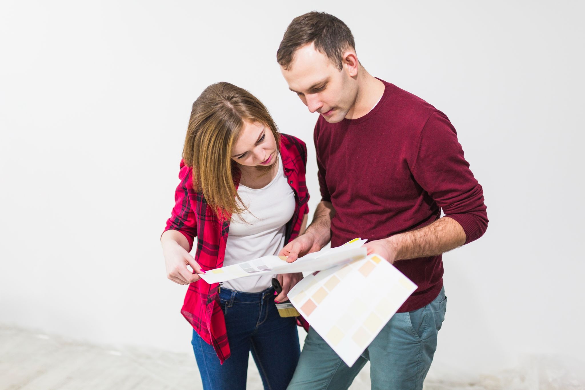 Couple reviewing renovation plans and building material samples during home renovation planning