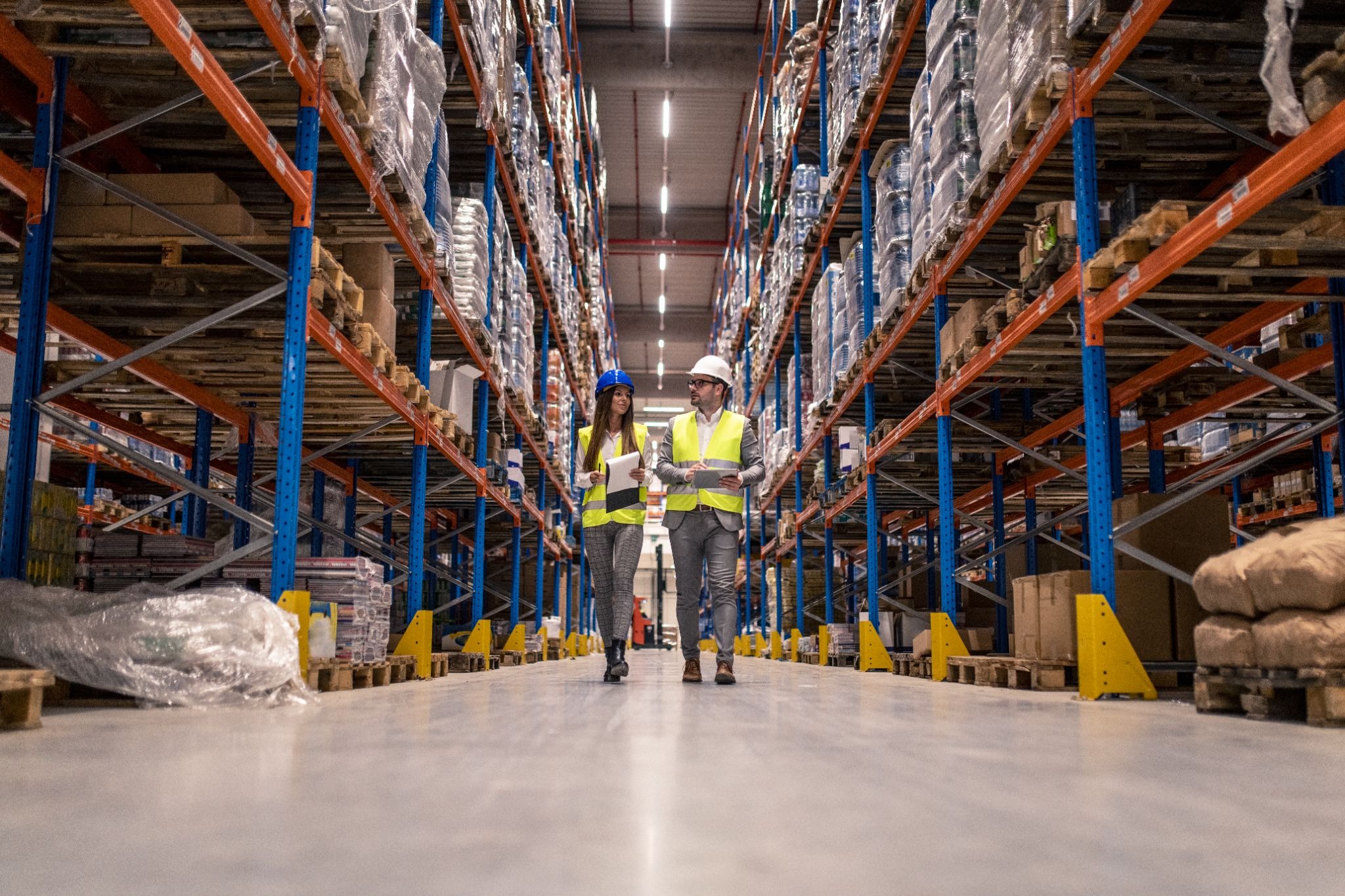 Two people walking through a warehouse filled with building materials in Dubai
